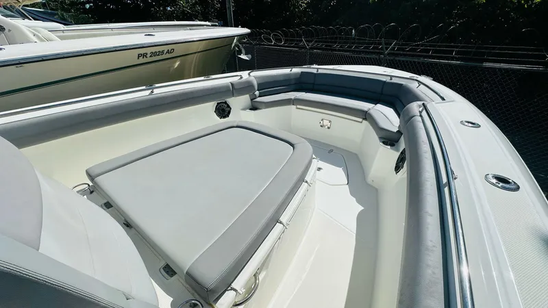  Yacht Photos Pics 2023 Boston Whaler 330 Outrage boat interior with cushioned seating and sleek design.