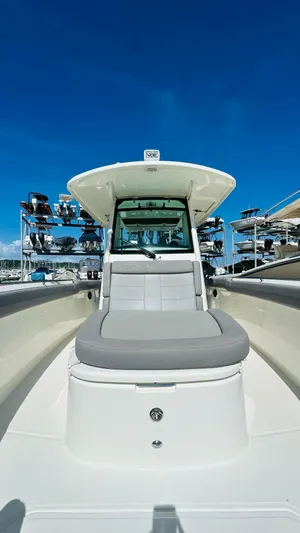  Yacht Photos Pics 2023 Boston Whaler 330 Outrage boat with sleek design under clear blue sky.