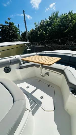  Yacht Photos Pics 2023 Boston Whaler 330 Outrage boat interior with seating and table under blue sky.