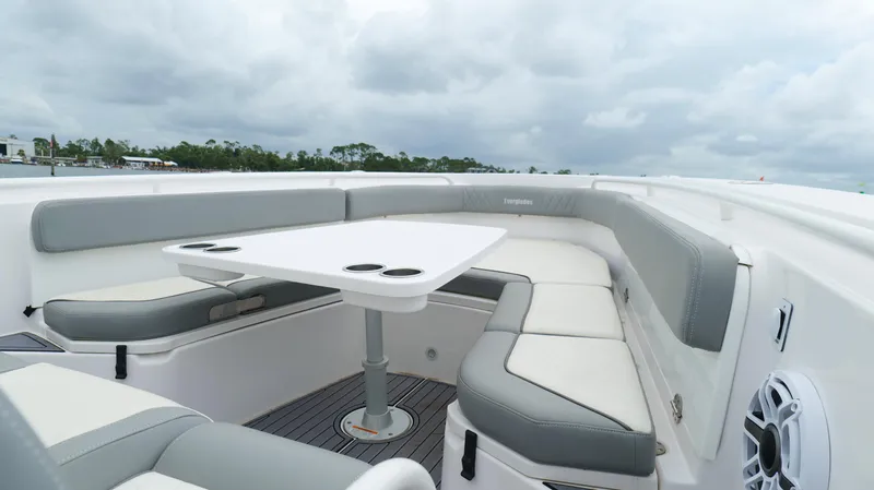 Engine Warranty Yacht Photos Pics 2023 Everglades 365 CC boat interior with cushioned seating and table under cloudy sky.