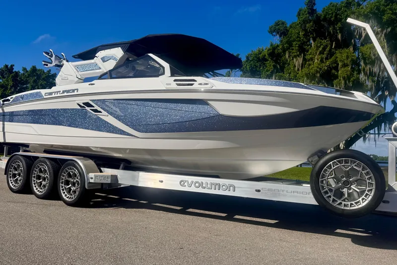  Yacht Photos Pics 2025 Centurion Ri245 boat on trailer, sleek design with metallic accents, parked outdoors.