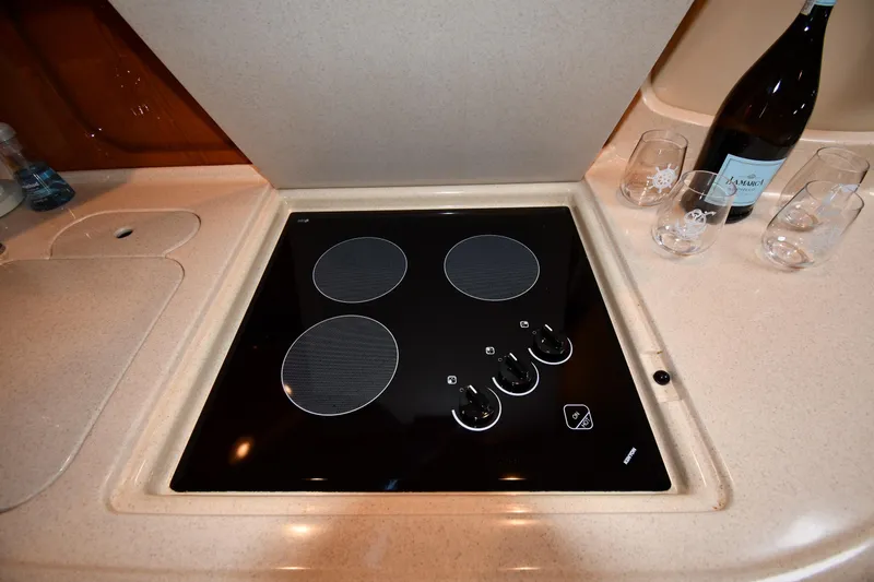  Yacht Photos Pics Stovetop in 2000 Sea Ray 460 Sundancer yacht kitchen with wine and glasses nearby.