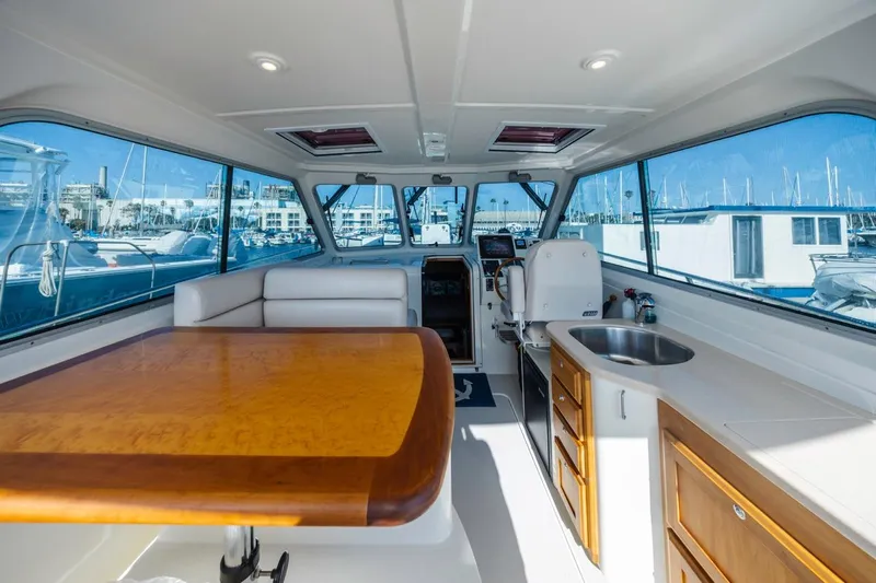 Kaholo Yacht Photos Pics Interior of a 2008 Back Cove 33 yacht with seating, table, and kitchenette.