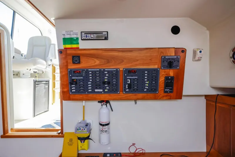 Kaholo Yacht Photos Pics Electrical panel inside a 2008 Back Cove 33 boat, featuring control switches and a fire extinguisher.