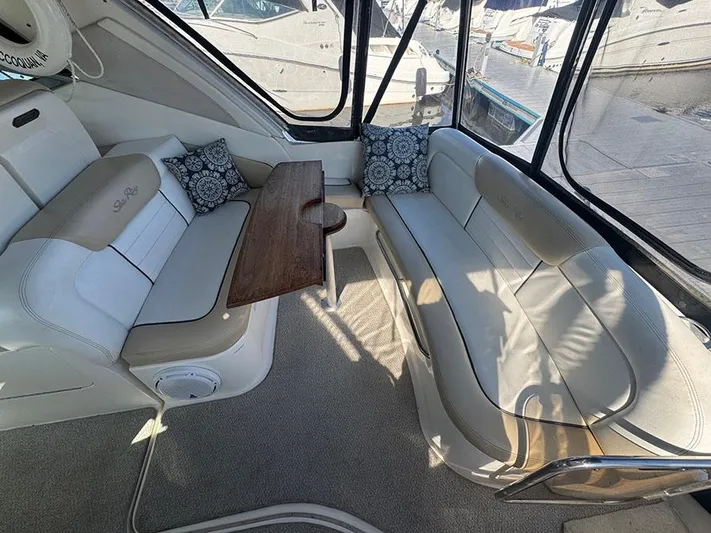  Yacht Photos Pics Interior of 2009 Sea Ray 330 Sundancer with cushioned seating and wooden table.