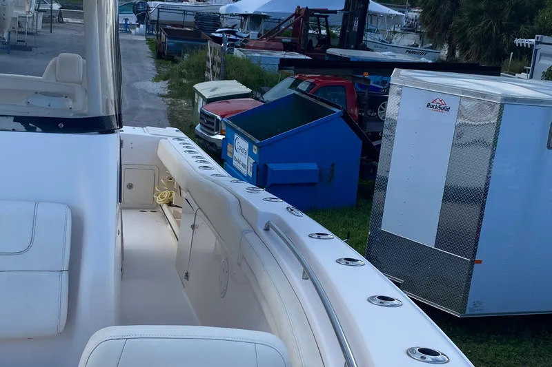  Yacht Photos Pics 2018 Grady-White Canyon 306 boat docked near trailers and equipment.