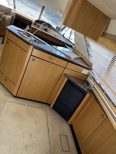  Yacht Photos Pics Interior of 2002 Bayliner 3988 Command Bridge Motoryacht with wooden cabinetry and compact kitchen.