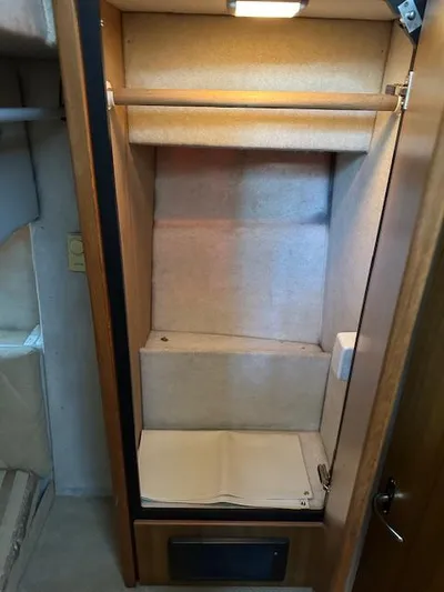  Yacht Photos Pics Empty closet inside 2002 Bayliner 3988 Command Bridge Motoryacht, featuring wooden finish and interior lighting.