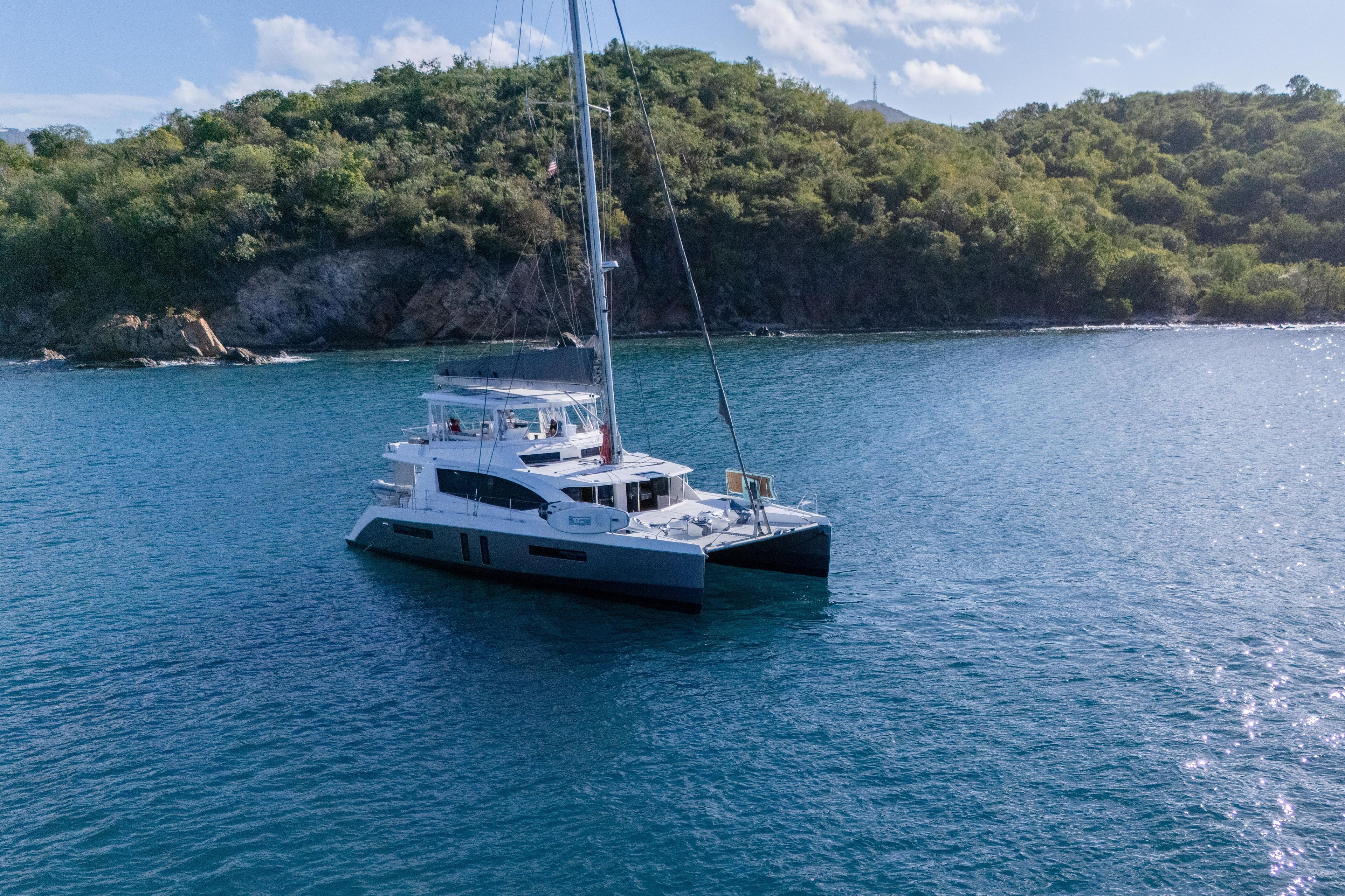Leopard 58 catamaran sailing near lush green island, 2014 model.