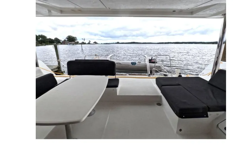 Rhapsody Yacht Photos Pics Lagoon 52 F 2021 yacht deck with seating, overlooking serene waters.