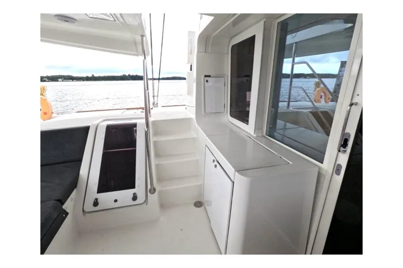 Rhapsody Yacht Photos Pics 2021 Lagoon 52 F yacht interior with sleek white cabinetry and waterfront view.