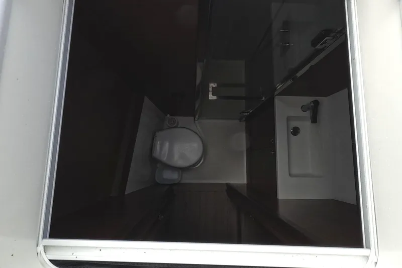 Rhapsody Yacht Photos Pics Compact bathroom interior of 2021 Lagoon 51 yacht, featuring toilet and sink.