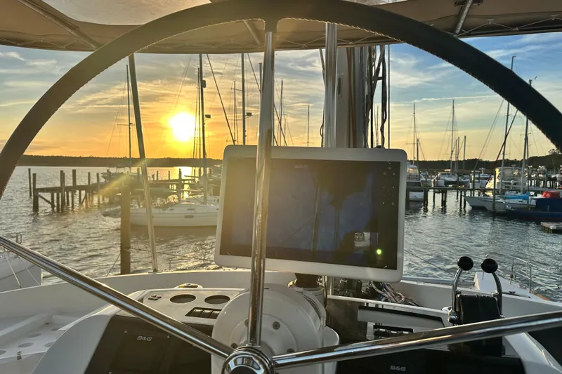 Rhapsody Yacht Photos Pics Helm of 2021 Lagoon 52 F catamaran at sunset in marina.