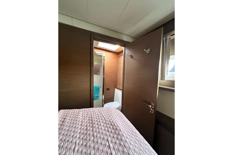 Rhapsody Yacht Photos Pics Interior of 2021 Lagoon 52 F yacht cabin with bed and bathroom view.
