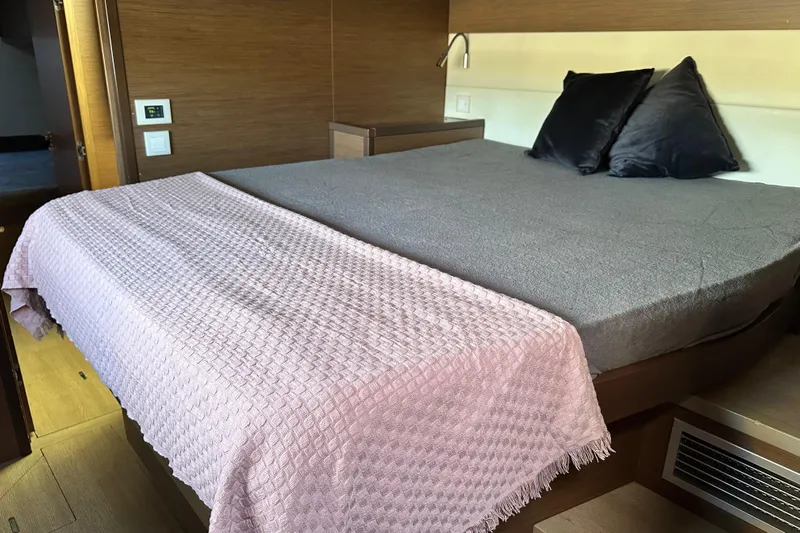 Rhapsody Yacht Photos Pics Luxurious bedroom interior of 2021 Lagoon 52 F yacht with cozy bedding and modern design.