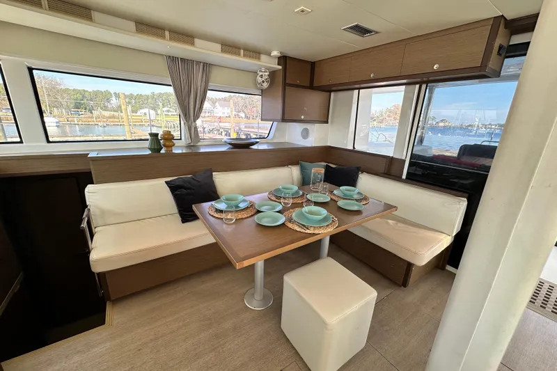 Rhapsody Yacht Photos Pics Interior of 2021 Lagoon 52 F yacht with elegant dining area and scenic window views.