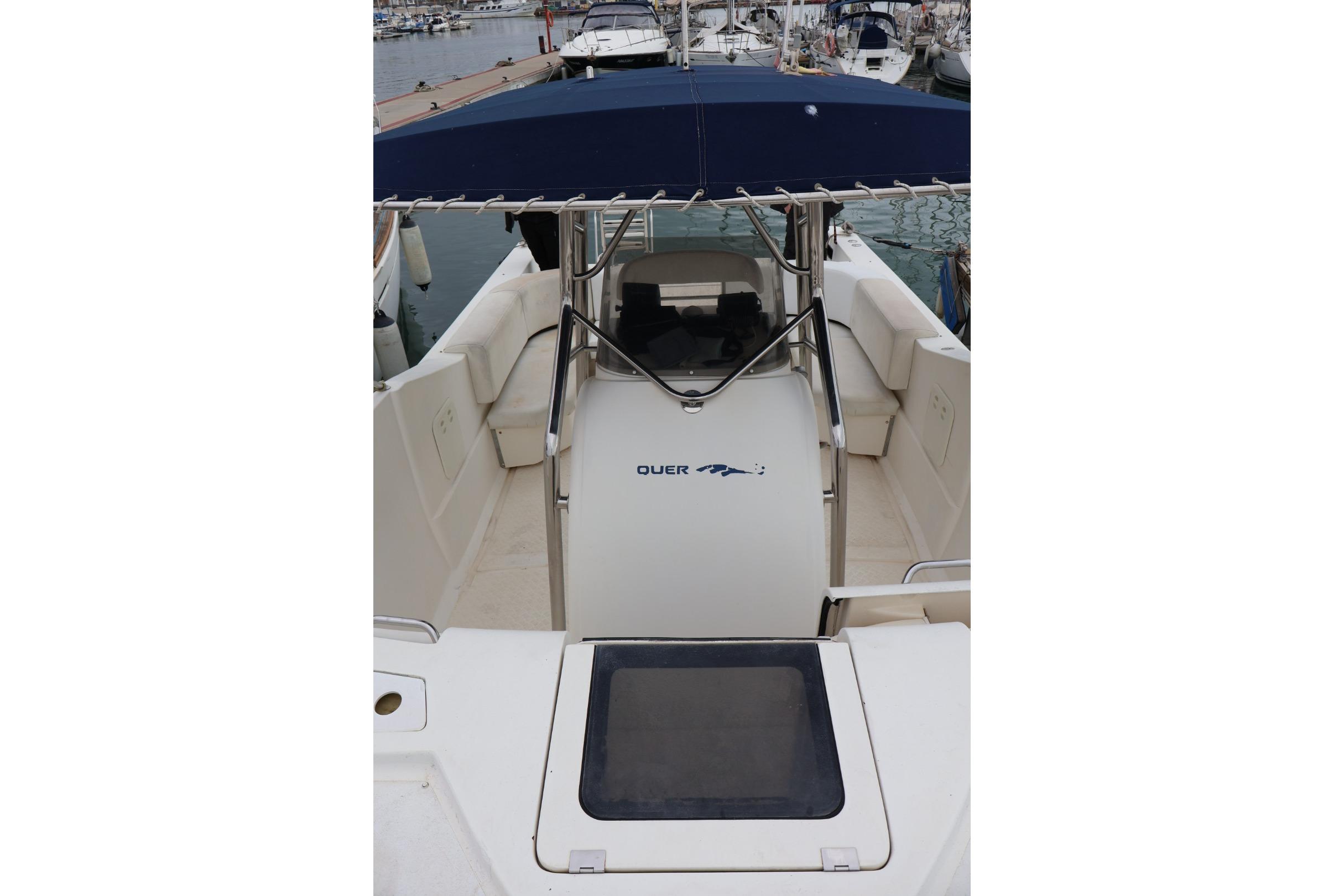 2004 Quer 32 Cuddy boat interior with seating and canopy in marina.