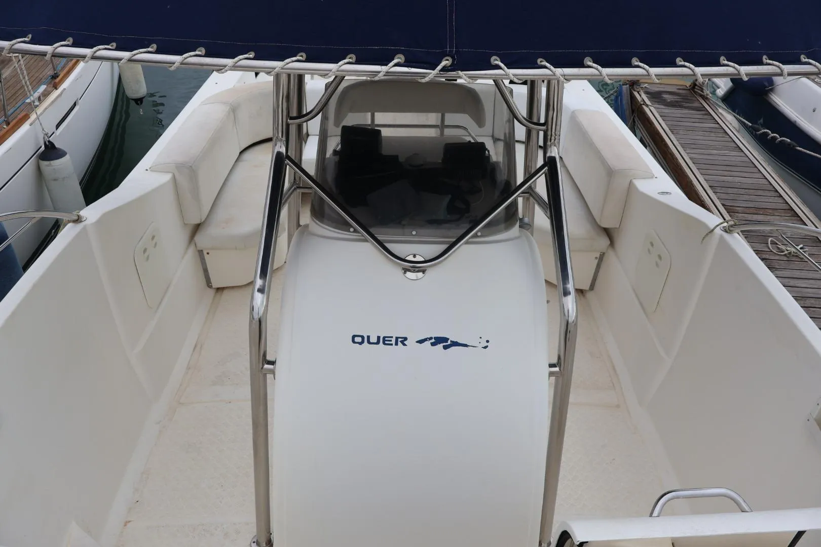 2004 Quer 32 Cuddy boat interior with seating and console, docked at marina.