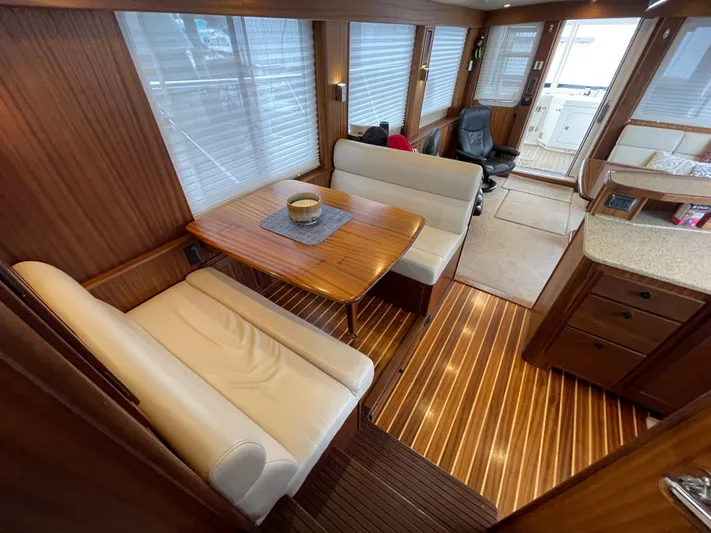 Pacific Rose Yacht Photos Pics Interior of 2009 American Tug 49 Limited with wooden flooring and dining area.