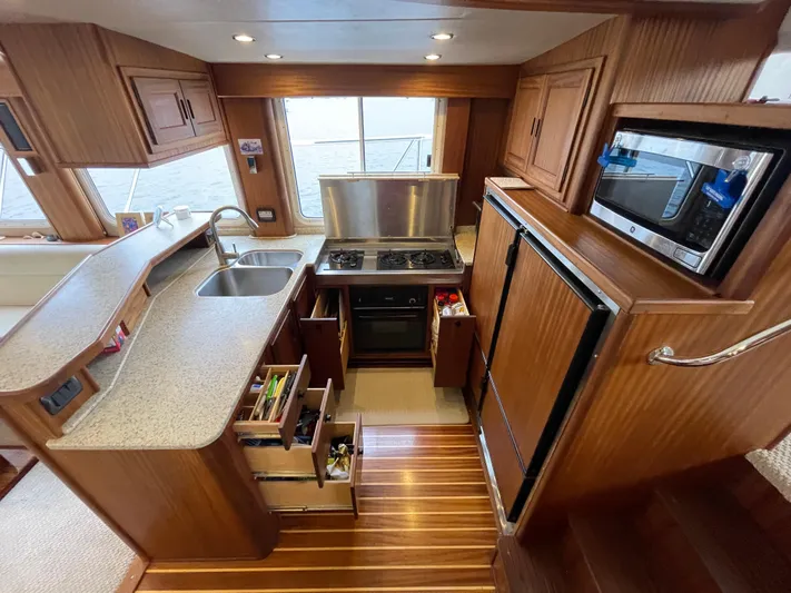 Pacific Rose Yacht Photos Pics 2009 American Tug 49 Limited kitchen with wood cabinetry, stove, sink, and refrigerator.