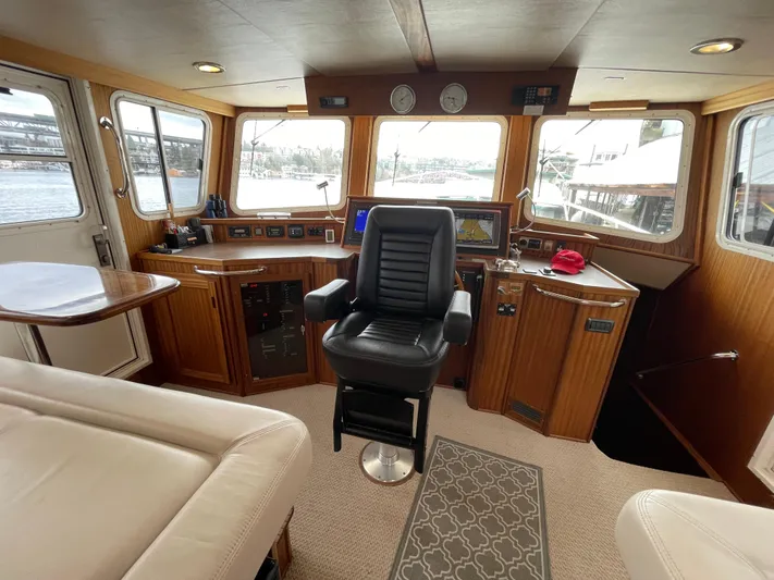 Pacific Rose Yacht Photos Pics Pilothouse interior of 2009 American Tug 49 Limited, featuring captain's chair and navigation equipment.