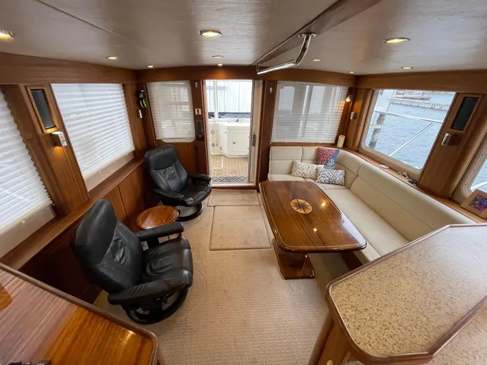 Pacific Rose Yacht Photos Pics Luxurious interior of 2009 American Tug 49 Limited with leather chairs and wooden accents.