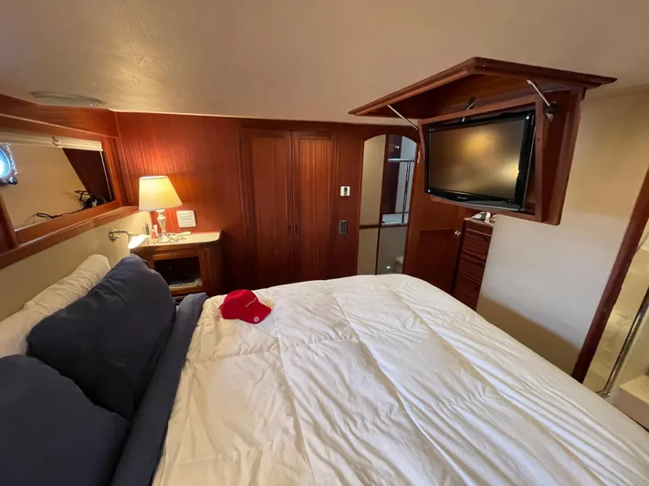 Pacific Rose Yacht Photos Pics Cozy bedroom in 2009 American Tug 49 Limited with TV, lamp, and wooden accents.