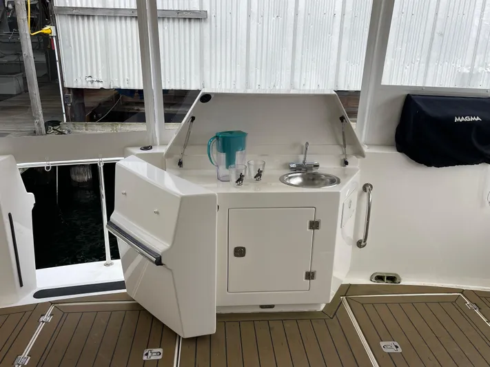 Pacific Rose Yacht Photos Pics Outdoor kitchenette on 2009 American Tug 49 Limited yacht with sink and storage.