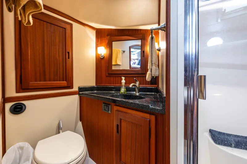 Pacific Rose Yacht Photos Pics Luxurious bathroom in 2009 American Tug 49 Limited yacht with wood accents and modern fixtures.