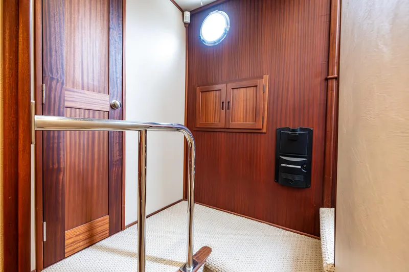 Pacific Rose Yacht Photos Pics Interior of 2009 American Tug 49 Limited, featuring wood paneling and a porthole window.
