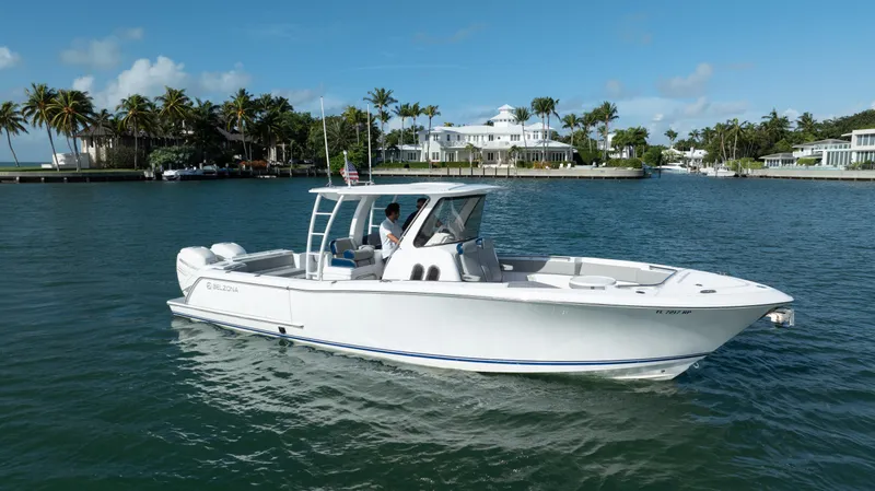  Yacht Photos Pics 2018 Belzona 325 Center Console boat cruising on a sunny day in a scenic waterfront area.