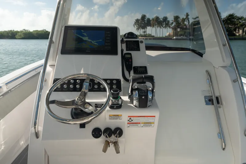  Yacht Photos Pics 2018 Belzona 325 Center Console boat dashboard with steering wheel and navigation controls.
