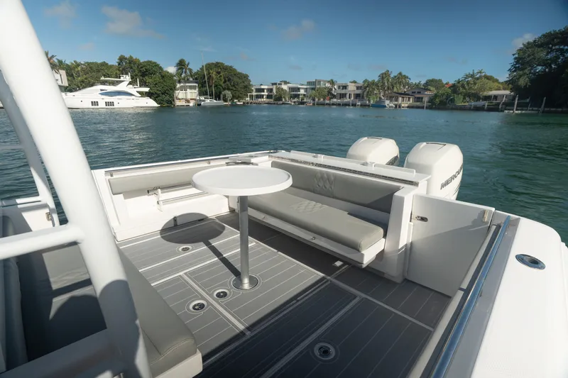  Yacht Photos Pics 2018 Belzona 325 Center Console boat with seating area and table on calm water.