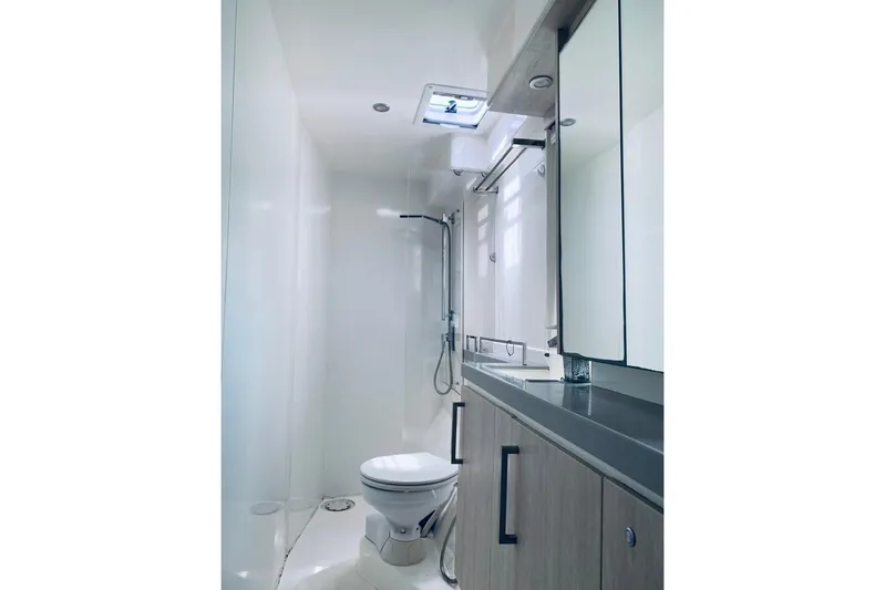  Yacht Photos Pics Modern yacht bathroom with sleek design, featuring a shower, toilet, and mirrored cabinets. Leopard 58, 2018.