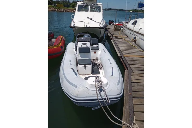  Yacht Photos Pics Inflatable boat docked beside a Leopard 58 yacht, 2018 model, on a sunny day.