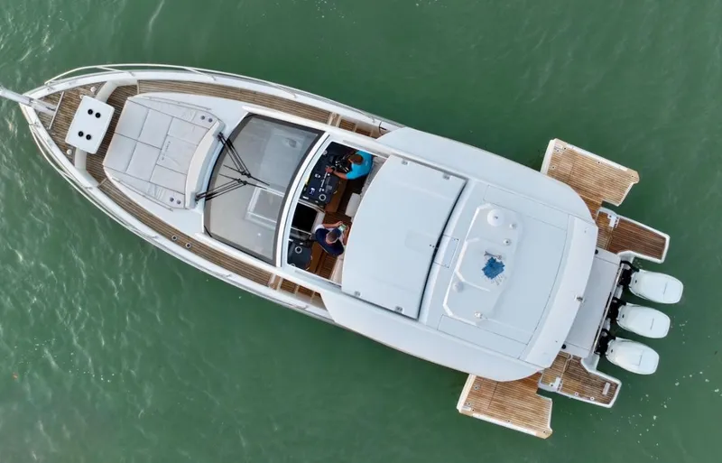  Yacht Photos Pics Aerial view of 2024 Jeanneau DB/43 OB boat on water, showcasing sleek design and triple outboard engines.
