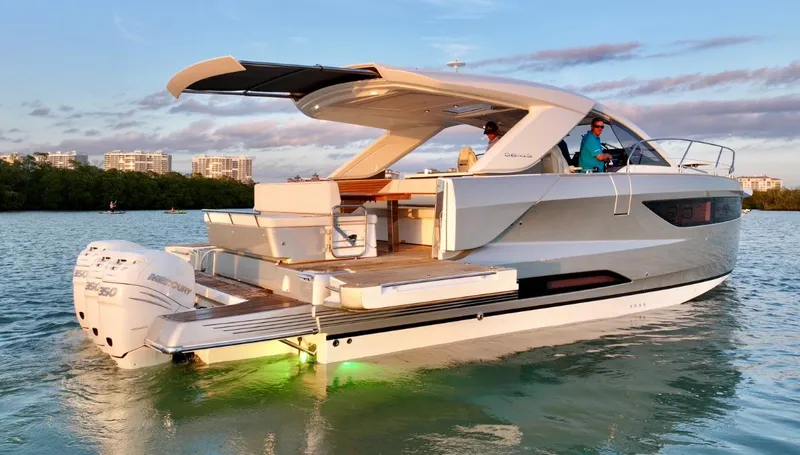  Yacht Photos Pics 2024 Jeanneau DB/43 OB luxury yacht on water at sunset, featuring sleek design and modern amenities.