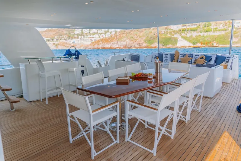  Yacht Photos Pics Luxurious 2023 custom motorsailer deck with dining area, bar, and ocean view.
