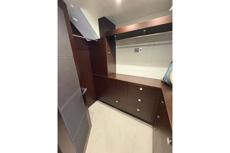  Yacht Photos Pics Luxurious walk-in closet on 2018 Sunseeker 86 Yacht with dark wood cabinetry.