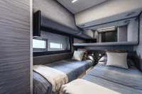 Luxurious 2023 Pershing 6X yacht cabin with twin beds and modern decor.