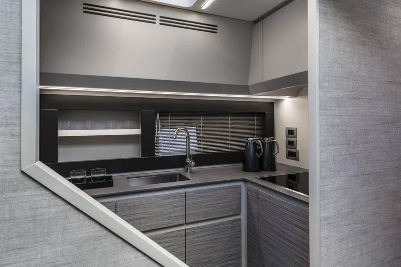  Yacht Photos Pics Modern kitchen interior of 2023 Pershing 6X yacht, featuring sleek cabinetry and stainless steel fixtures.