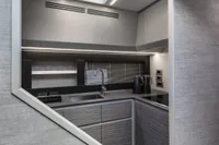 Modern kitchen interior of 2023 Pershing 6X yacht, featuring sleek cabinetry and stainless steel fixtures.