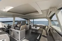 Luxurious interior of 2023 Pershing 6X yacht with ocean view and modern seating.
