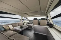 Luxurious interior of 2023 Pershing 6X yacht with modern seating and ocean view.