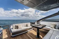 Luxury deck of 2023 Pershing 6X yacht with ocean view and elegant seating.