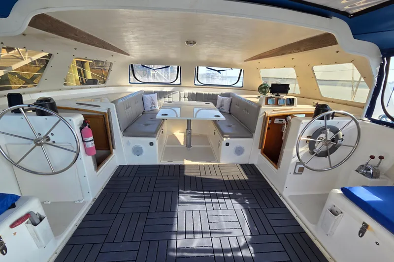 Prosecco Yacht Photos Pics Interior of a 1997 Seawind 1000 catamaran with dual steering wheels and seating area.