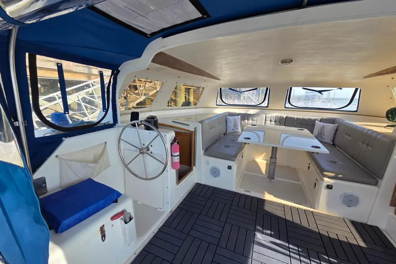 Prosecco Yacht Photos Pics Interior of a 1997 Seawind 1000 catamaran with seating, table, and steering wheel.