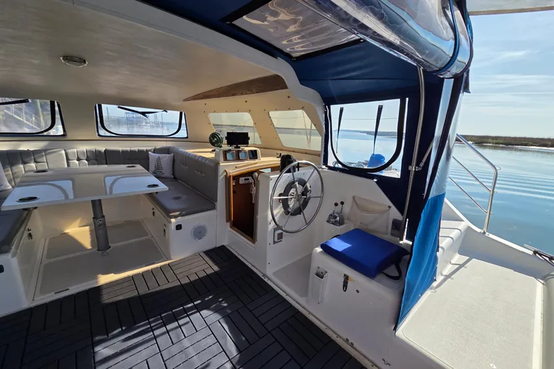 Prosecco Yacht Photos Pics Interior of a 1997 Seawind 1000 catamaran with helm, seating, and table.