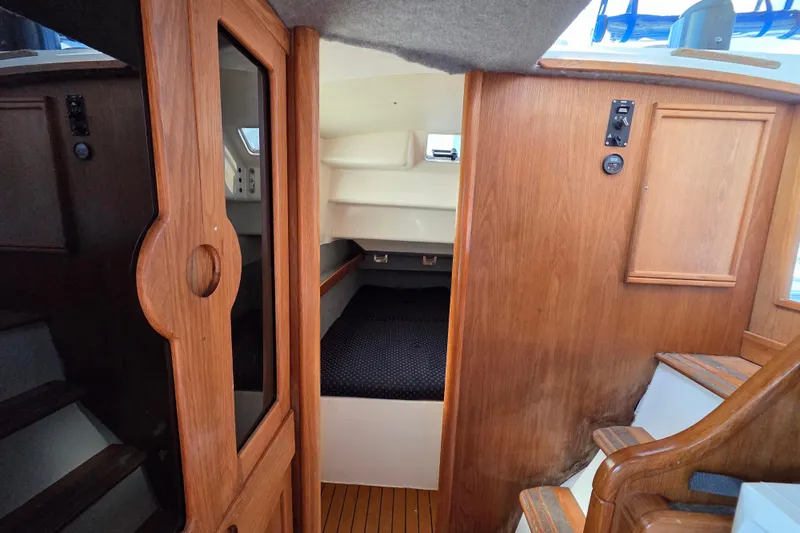 Prosecco Yacht Photos Pics Interior of a 1997 Seawind 1000 catamaran, featuring wooden cabinetry and cozy sleeping quarters.