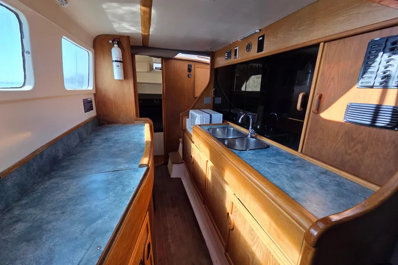 Prosecco Yacht Photos Pics Interior of 1997 Seawind 1000 catamaran with wooden cabinetry and dual sink.